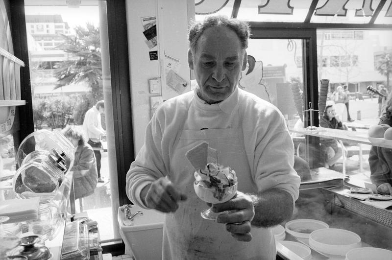 Black and white image of ice cream being created by Joe Di Maio in his ice cream shop.