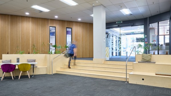 The entrance has wide automatic doors with a ramp on the right side and steps in the centre at Central Library.