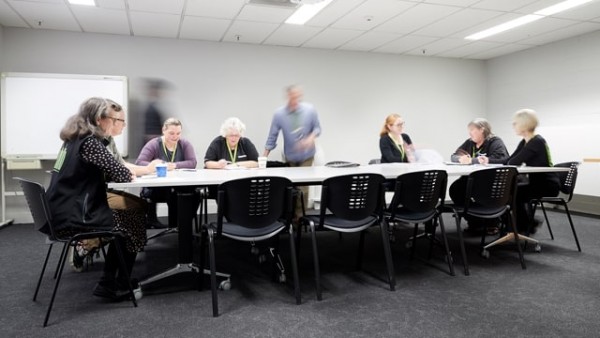 A meeting happening in Kathleen Glenn Room with 9 people sitting around the table. 