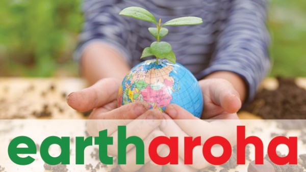 Hands in a garden bed holding a small globe with a seedling sprouting from it. The words Earth Aroha are at the bottom of the image, Earth in green and Aroha in red.
