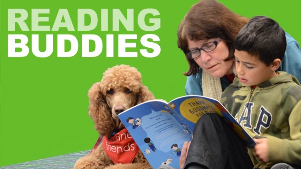 Child and woman reading to therapy dog